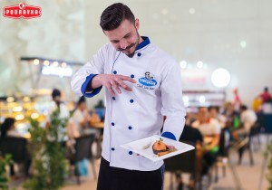 Handsome man cooking at home preparing salad in kitchen.