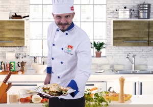 Handsome man cooking at home preparing salad in kitchen.