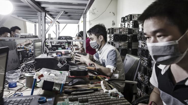 Tehnicienii fac reparații la mașinile de extragere a bitcoinului la o instalație minieră operată de Bitmain în Ordos, Mongolia Interioară,